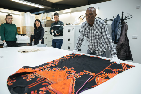 Volunteer-Nav lays out a dress from Saraqib in Syria credit: Ian Wallman