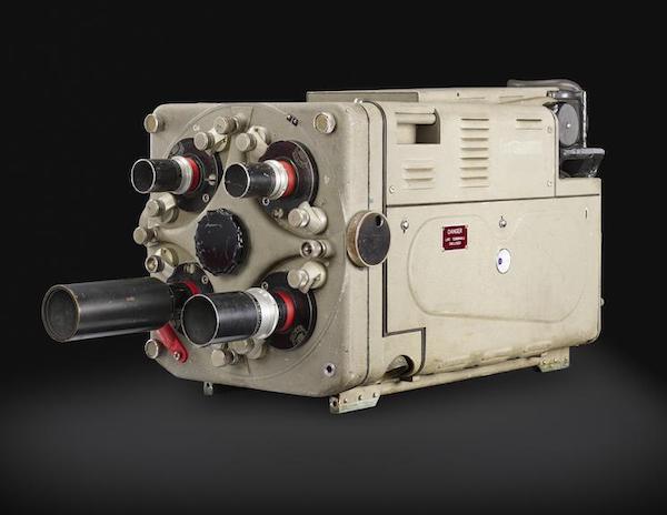Photograph of a large, rectangular, monochrome television camera head, characterized by a grey/green metal casing, a manual four-lens turret.